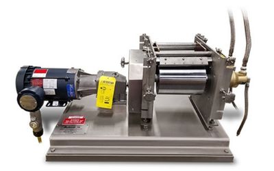 Bench-top screw press with electric motor on the left, mounted on a metal base used for pressing or stamping operations.